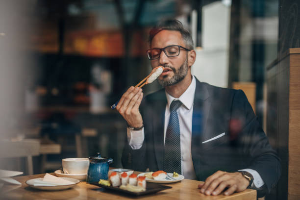 istock Man eating sushi in the restaurant 1157986627