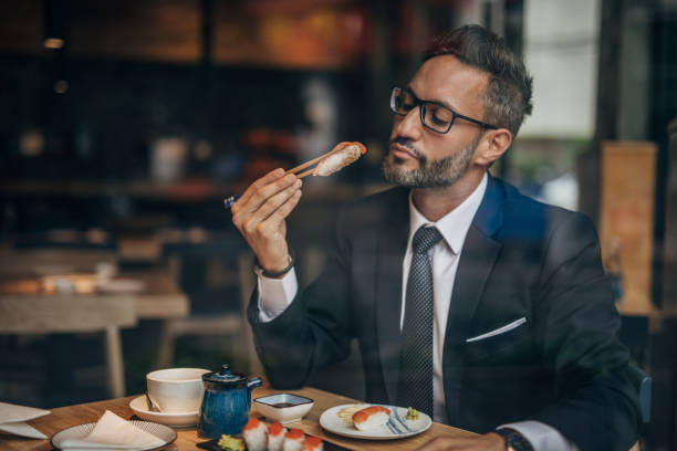 istock Man eating sushi in the restaurant 1157986656