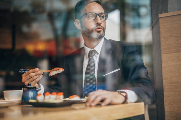 istock Man eating sushi in the restaurant 1157986675