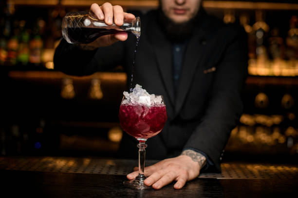 istock Bartender pours alcohol cocktail in glass with ice 1157986789
