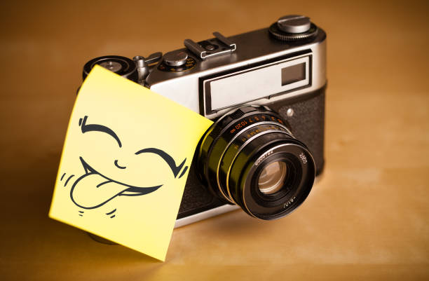 Drawn smiley face on a post-it note sticked on a photo camera