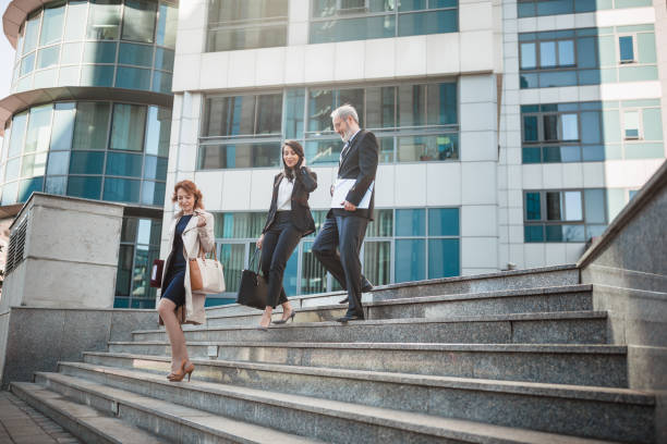 istock Business people walking down concrete steps 1157987924