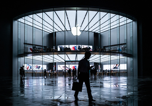 Nanjing, China - June 20, 2019: Apple stores in the evening, busy Apple stores and people on the road.