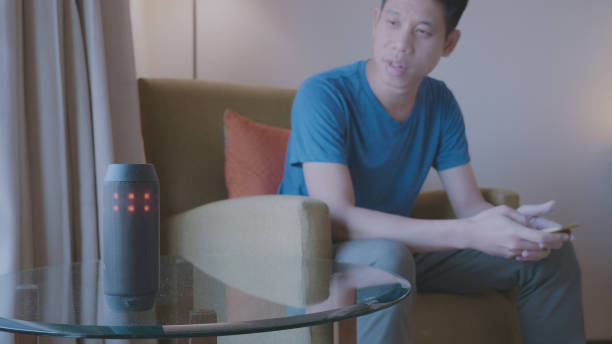 istock Young millennial using smart voice to control room devices in their apartment 1157988546