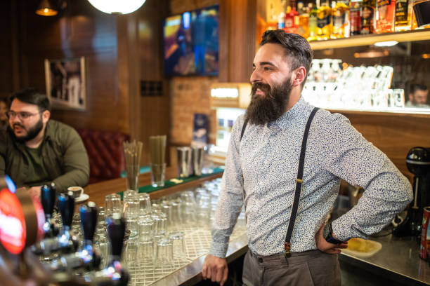 istock Cheerful bartender standing over bar counter in a pub 1157991090