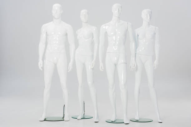 maniquíes de plástico blanco en la fila sobre gris - mannequin fotografías e imágenes de stock