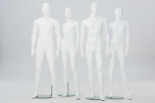 white plastic mannequins in row on grey