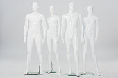 white plastic mannequins in row on grey