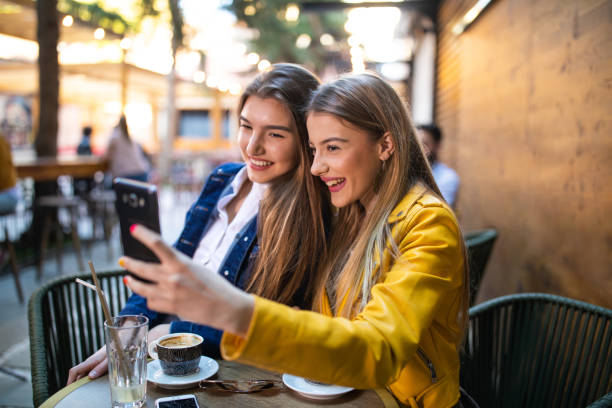 istock Modern girls taking selfie in sidewalk cafe 1157992155