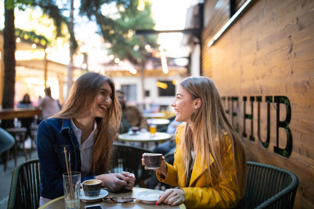 tiempo de gossip para amigas en el café - young adult lifestyles city life drinking fotografías e imágenes de stock