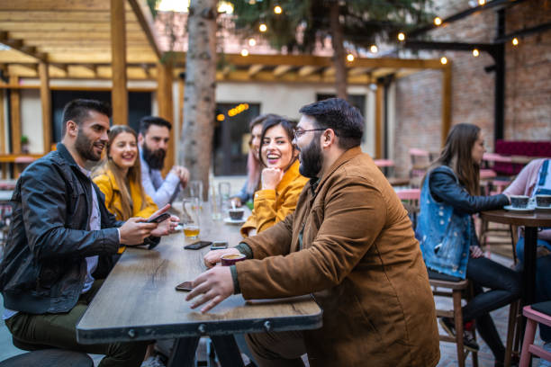 istock Colleagues sitting in sidewalk cafe after work 1157992230
