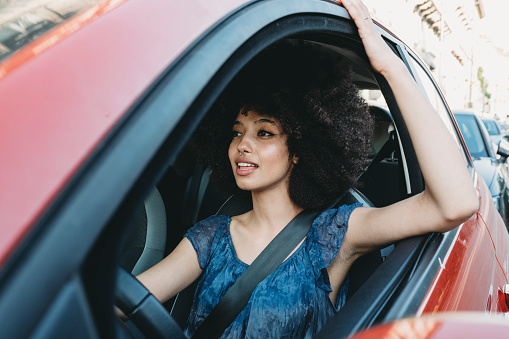 Young adult woman with afro hair in the car