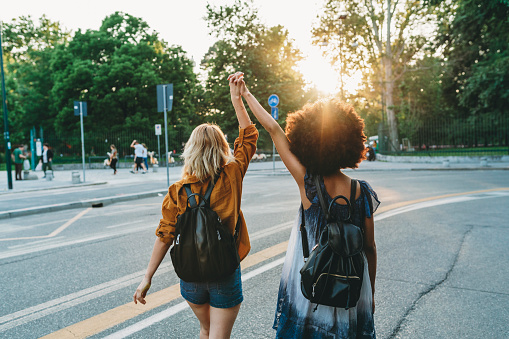 Two friends walking together in the city at sunset