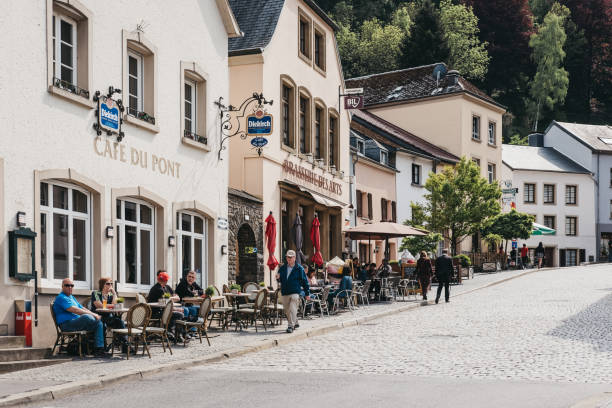 People walk past Cafe du Pont and Brasserie des Arts restaurant in Vianden, Luxembourg. Vianden, Luxembourg - May 18, 2019: People walk past Cafe du Pont and Brasserie des Arts restaurant in Vianden, town in Luxembourgs Ardennes region known for the centuries-old hilltop Vianden Castle. vianden stock pictures, royalty-free photos & images