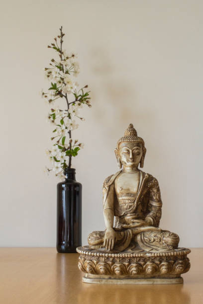 istock Spring blossom flowers behind Buddha statuette 1157994298