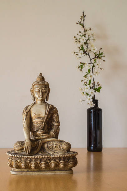 istock Spring blossom flowers behind Buddha statuette 1157994644