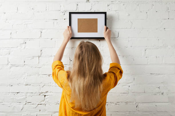 istock back view of woman holding blank frame in hands 1157994748