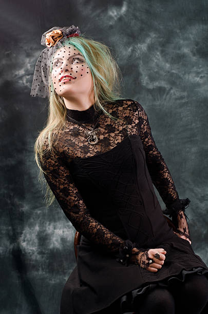 istock Goth girl with retro hat poses at studio 115799549