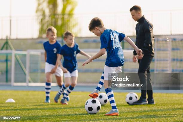 Football Training Practice Exercises For Youth Soccer Players Boys On Training With Soccer Balls On Pitch Stock Photo - Download Image Now