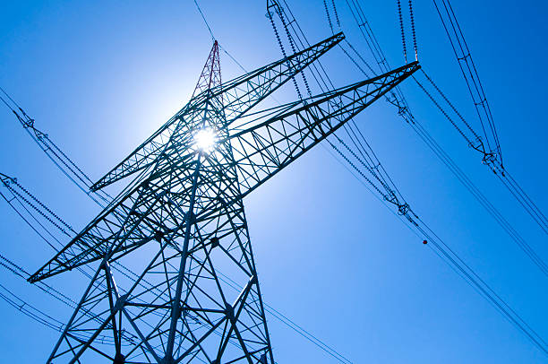 Electricity pylon with blue sky and sun Electricity pylon with blue sky and sun iron county wisconsin stock pictures, royalty-free photos & images