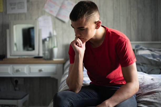Stressing Over Exams Emotional, low lighting shot of a teenage boy stressed about exams. teenage boys stock pictures, royalty-free photos & images
