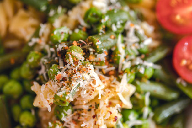 Fussili with peas, green beans, and baby onion leaves, close-up