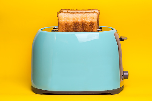 bright, fun breakfast. cyan color toaster on a wooden background 