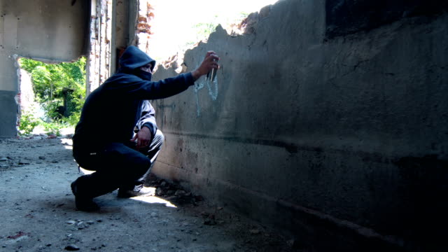 Man With Mask and Hoodie Doing Graffiti