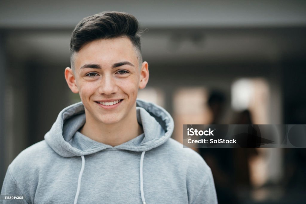 Headshot of a Teenage Boy Portrait of a smiling teenager looking at the camera and smiling. Teenager Stock Photo