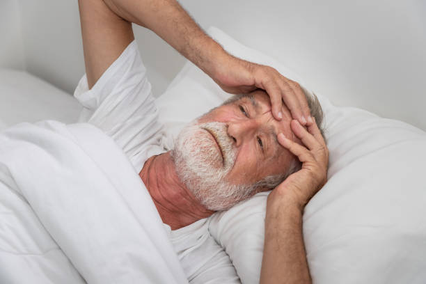 istock Senior elderly man on bed eye open sleeplessness and worry, with white blanket in bedroom 1158017534