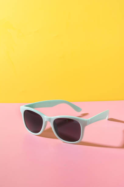 istock Sun glasses with shadow on creative yellow and pink background. Close up. Summer concept. 1158019122