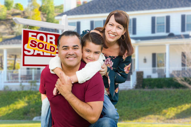 Happy Mixed Race Family In Front of House and Sold For Sale Real Estate Sign Happy Mixed Race Family In Front of House and Sold For Sale Real Estate Sign. house for sale by owner stock pictures, royalty-free photos & images