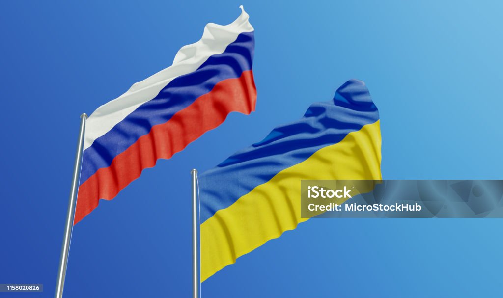Russian and Ukrainian Flags Waving With Wind Russian and Ukrainian flags are waving with wind over  blue sky. Low angle view. Dispute and conflict concept. Horizontal composition with copy space. Ukraine Stock Photo