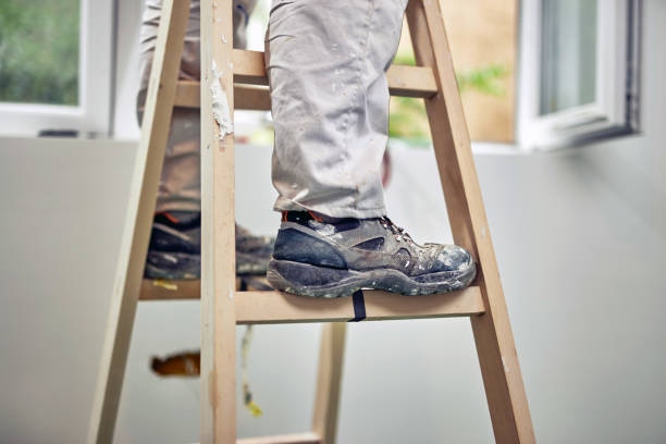 istock Worker standing on the ladder and renovating house. 1158021059