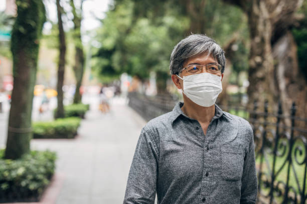 Senior man with mask walking on the street