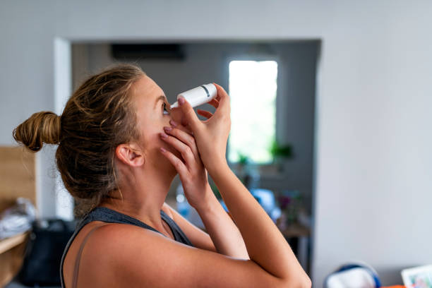 Caucasian woman inserting eye-drops Photo of a woman using eye drop. Female dropping eye lubricant to treat dry eye or allergy. Sick girl treating eyeball irritation or inflammation; sick woman suffering from irritated eye, optical symptoms. eyedropper stock pictures, royalty-free photos & images