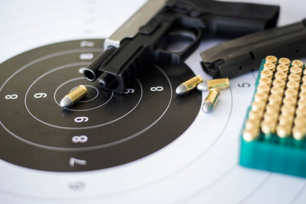 istock Guns with ammunition on paper target shooting   practice 1158022480