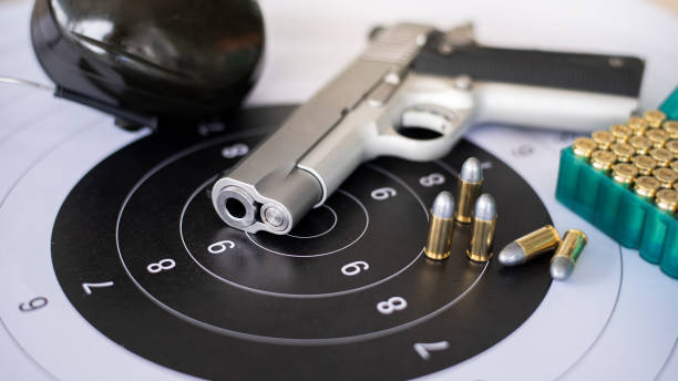 istock Guns with ammunition on paper target shooting   practice 1158022481