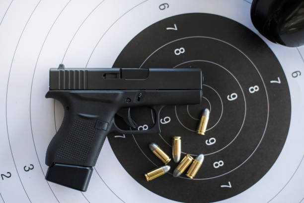 istock Guns with ammunition on paper target shooting   practice 1158022671