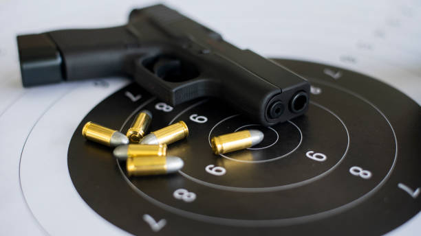 istock Guns with ammunition on paper target shooting   practice 1158022699