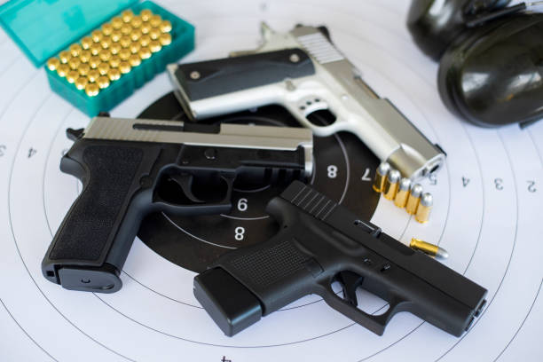 istock Guns with ammunition on paper target shooting   practice 1158022703
