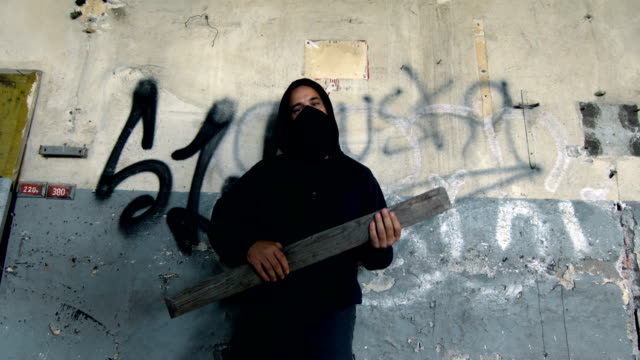 Man With Mask And Hoodie Holding A Plank