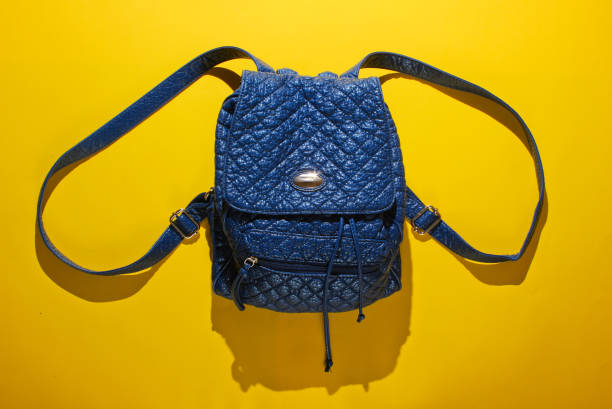 Leather backpack with straps on a yellow background. Top view, minimalism fashion