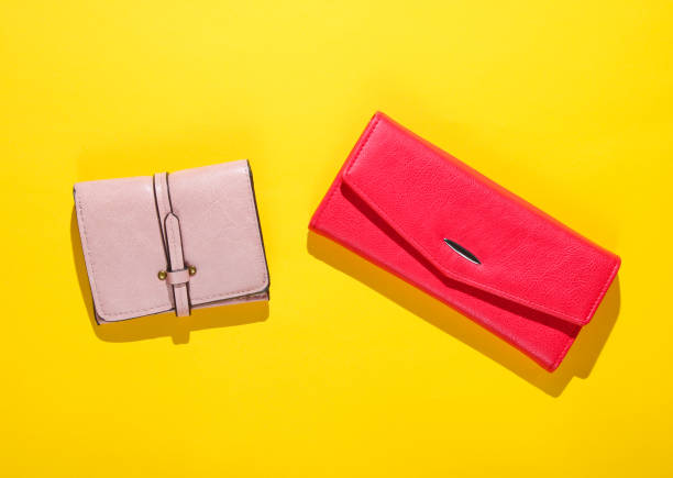 istock Pink and red leather wallets on a yellow background. Top view 1158026802