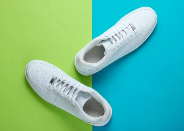 istock Fashionable white sneakers on a two-tone background. Top view 1158027061