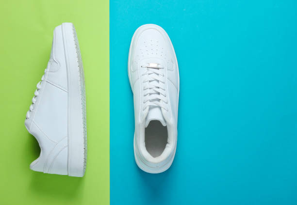 istock Fashionable white sneakers on a two-tone background. Top view 1158027062