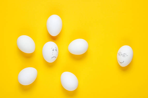 istock Bullying concept with eggs on yellow background. Top view, minimalism 1158028381