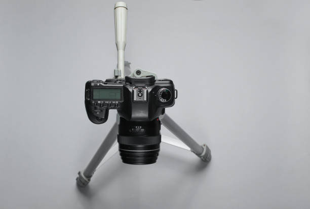 istock Modern digital camera with tripod on gray background. Top view 1158028578