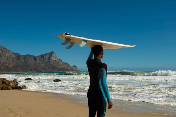 Teenage boy with surfboard at beach