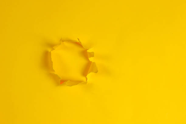 istock Hole of torn yellow paper. Copy space 1158031197